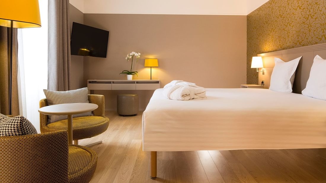 Bed, loungers & TV in Prestige Room at Oceania Le Jura Dijon
