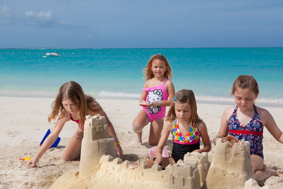 Kids building sand castle near The Somerset on Grace Bay