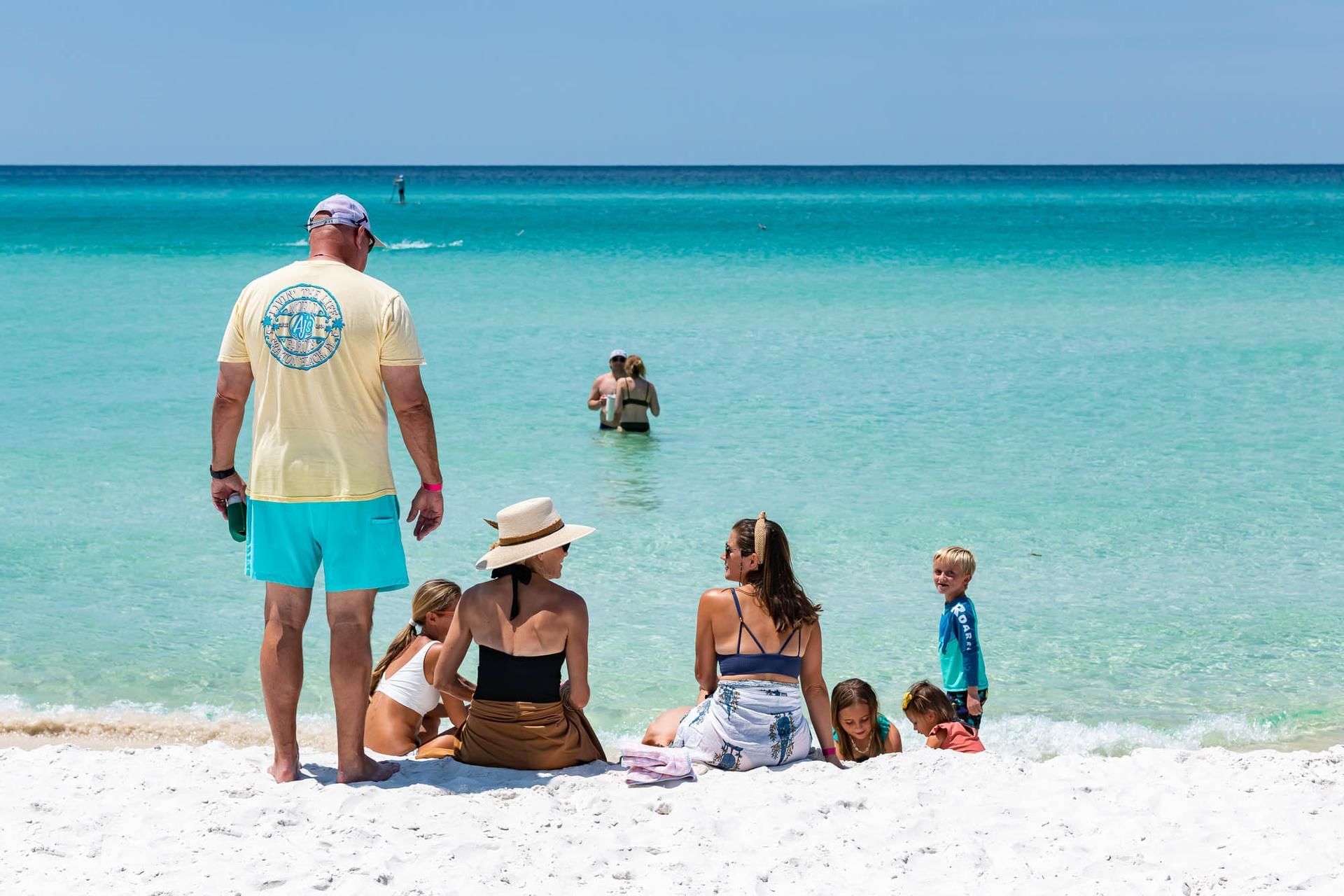 Family gathered by the beach on a sunny day at Watersound Inn