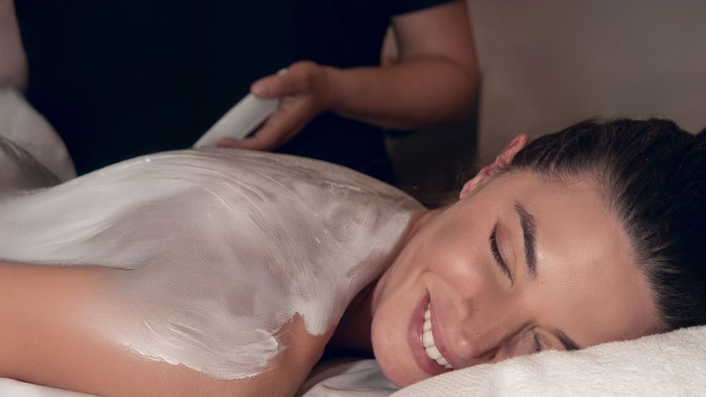 Woman lying down covered in exfoliating cream at the Hotel Marquis Reforma in Mexico City.