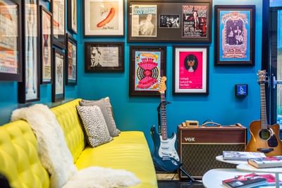 Lobby with yellow couch and lots of framed music posters at The Verb Hotel