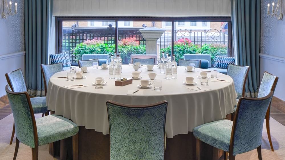 A bright, round banquet table set for a business meeting or tea party at Warwick Hotels and Resorts