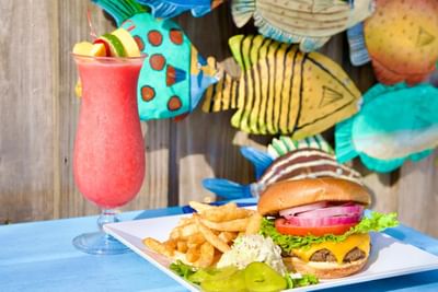 Close-up of burger & fries served with a cocktail at Trianon Bonita Bay