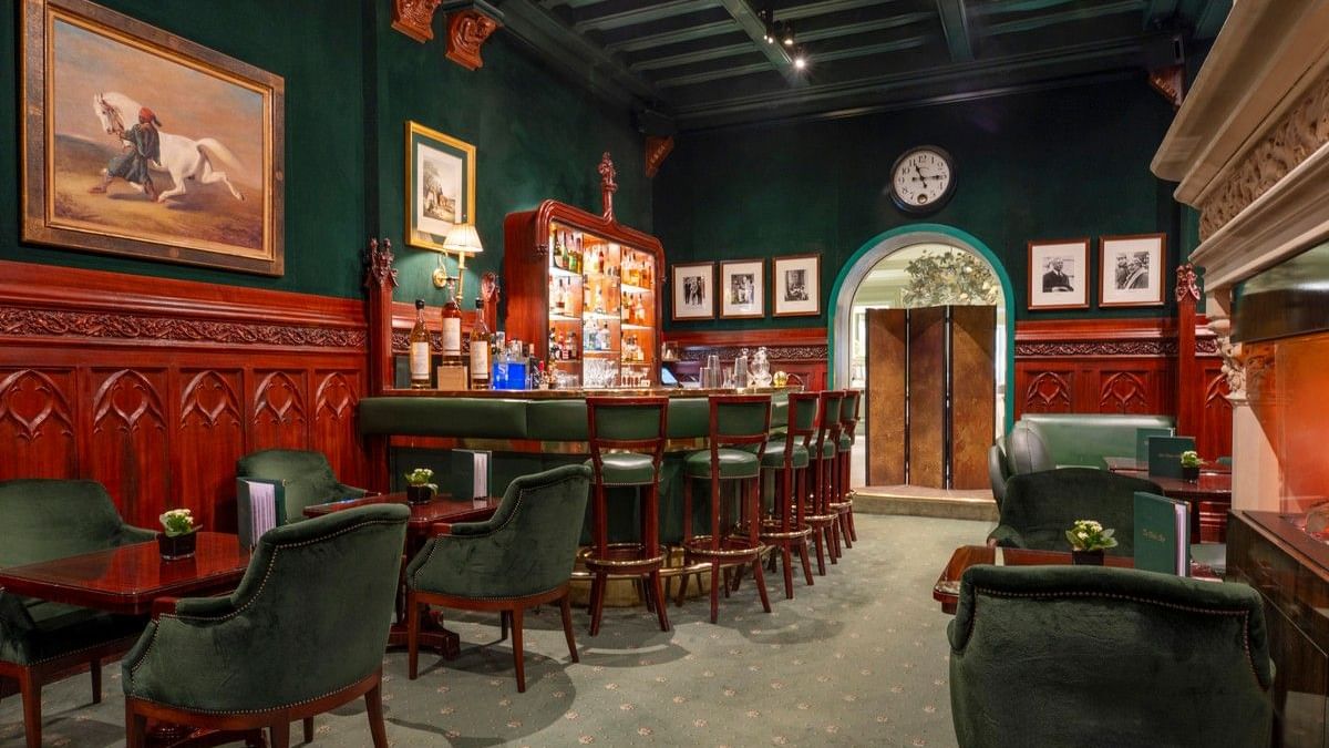 Duke's Bar area with green velvet armchairs surrounding tables, set by a green-paneled wall at Hotel Westminster Paris