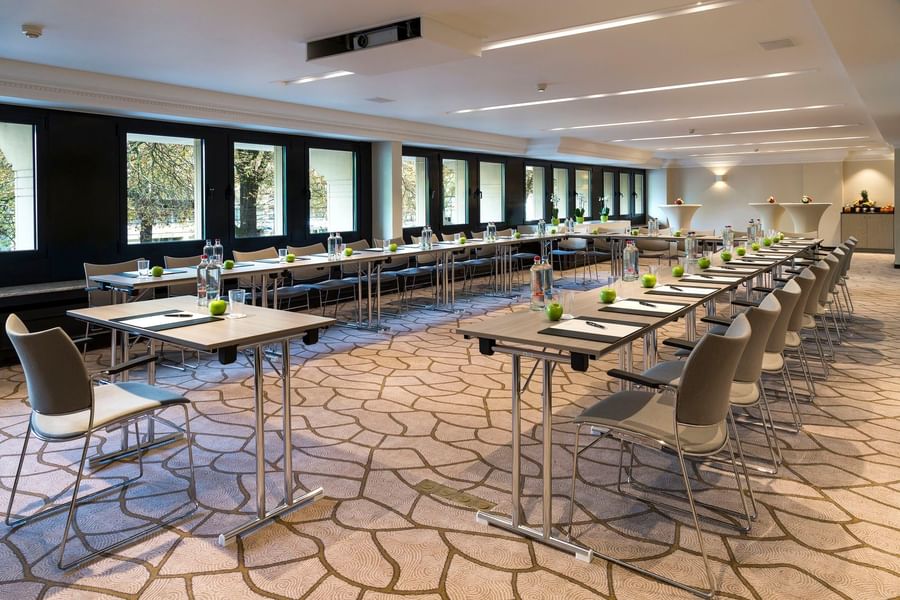 Moderne vergaderzaal met rijen tafels, stoelen, waterflessen en groene appels bij Hotel Barsey by Warwick Brussels Bruxelles