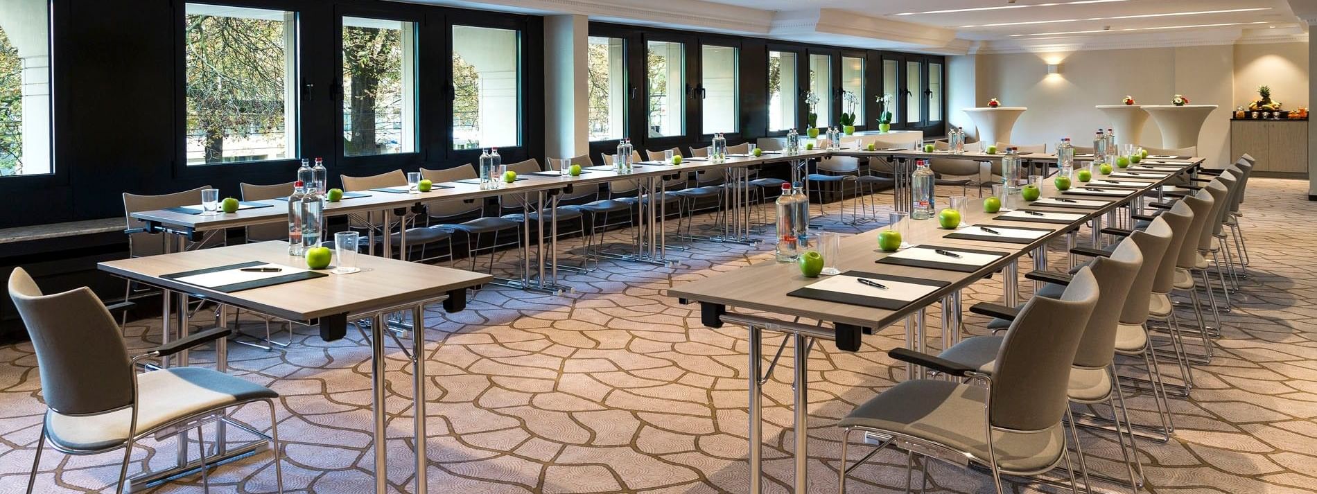 Salle de réception équipée de tables et de chaises à l'hôtel Barsey by Warwick à Bruxelles.