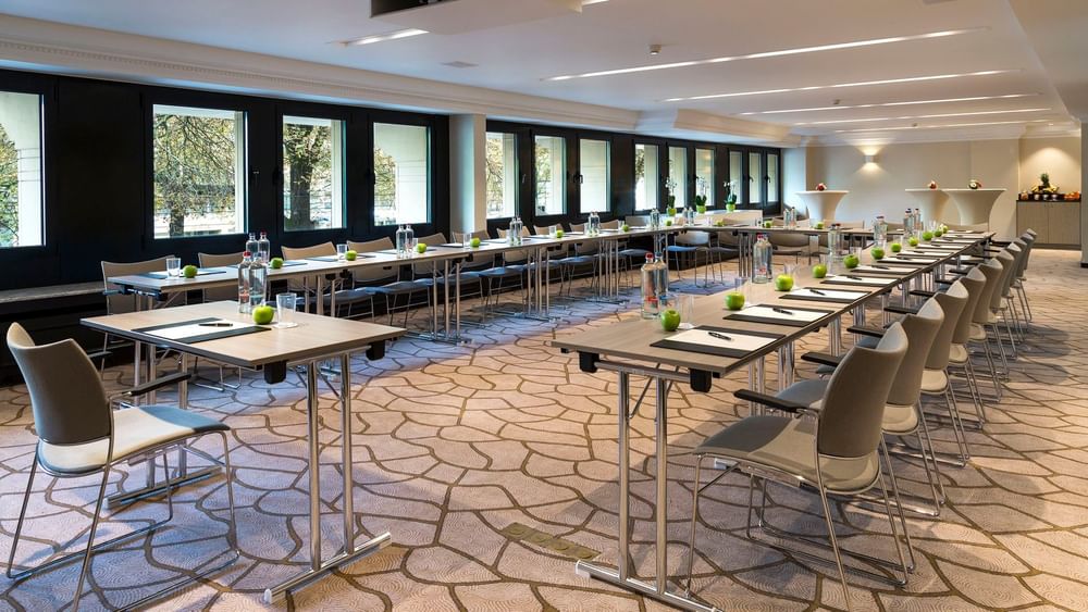 Salle de réception équipée de tables et de chaises à l'hôtel Barsey by Warwick à Bruxelles.