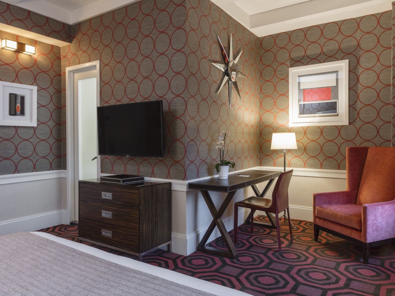 wall mounted tv above a desk in a hotel room