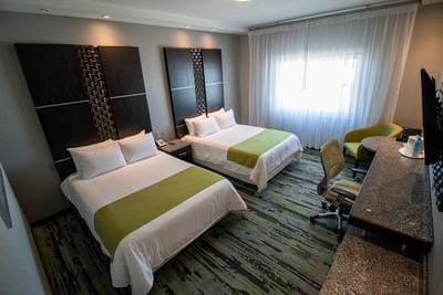 Standard Room with two white beds under tall headboards at Hotel Mirra, a hotel near US border crossing San Luis, Sonora