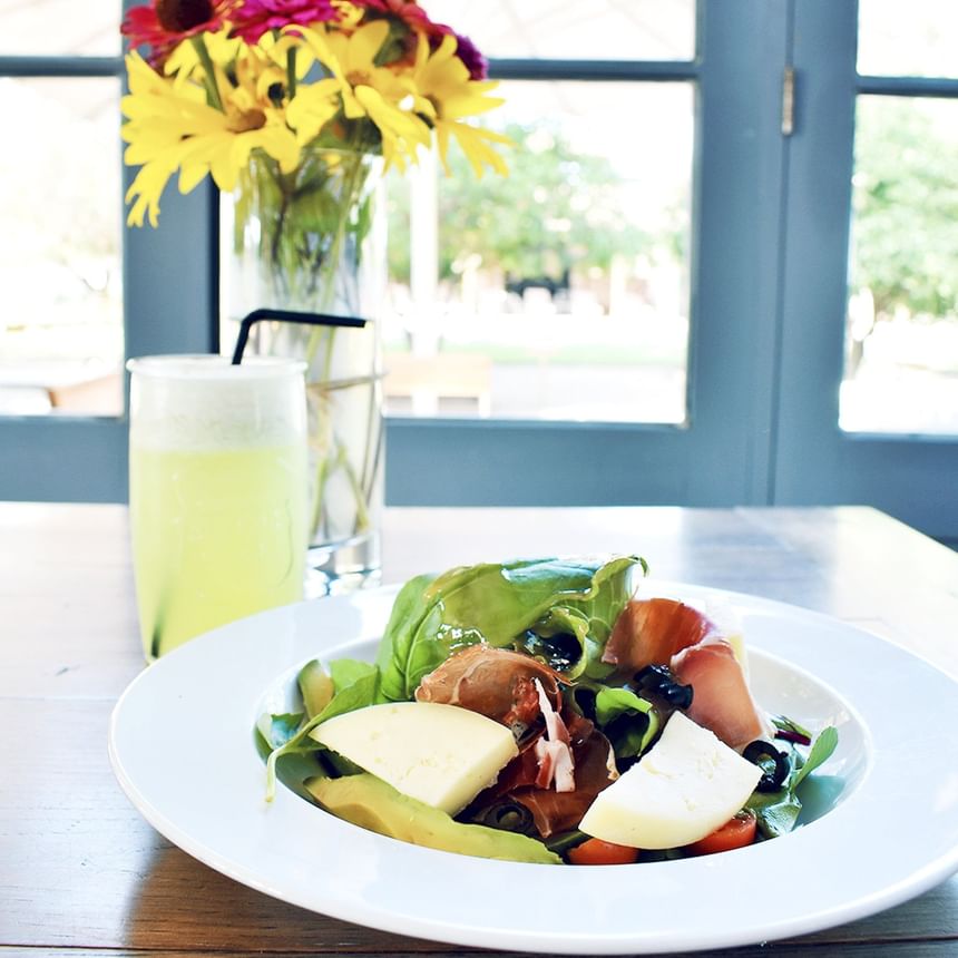 Plated salad & a glass of a green beverage served in Ensamblaje Restaurant, best dining Santa Cruz at NOI Blend Colchagua