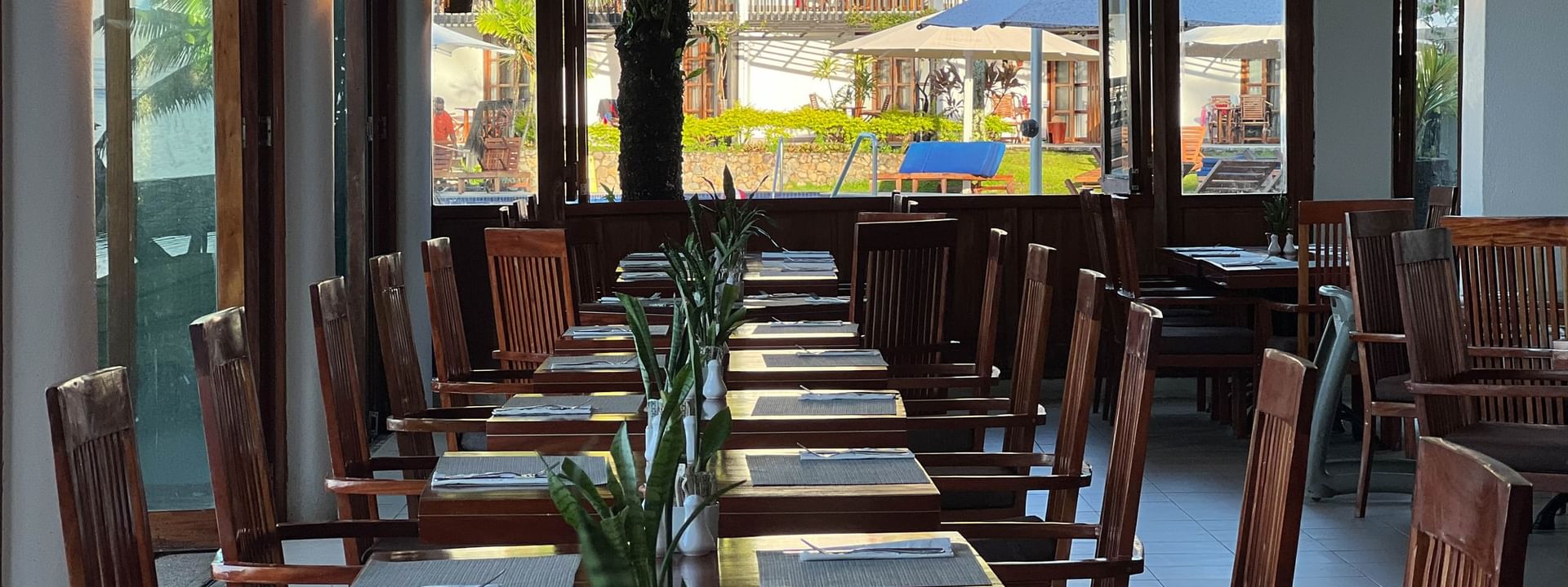 Dining area with wooden tables and chairs at Bula Brasserie, Warwick Fiji Resort and Spa, Korolevu