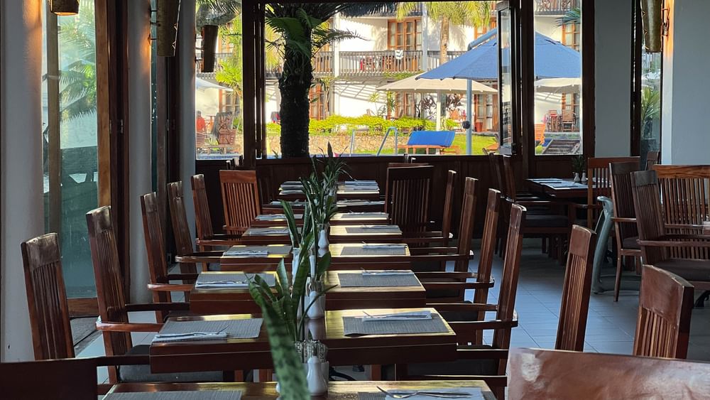 Dining area with wooden tables and chairs at Bula Brasserie, Warwick Fiji Resort and Spa, Korolevu.