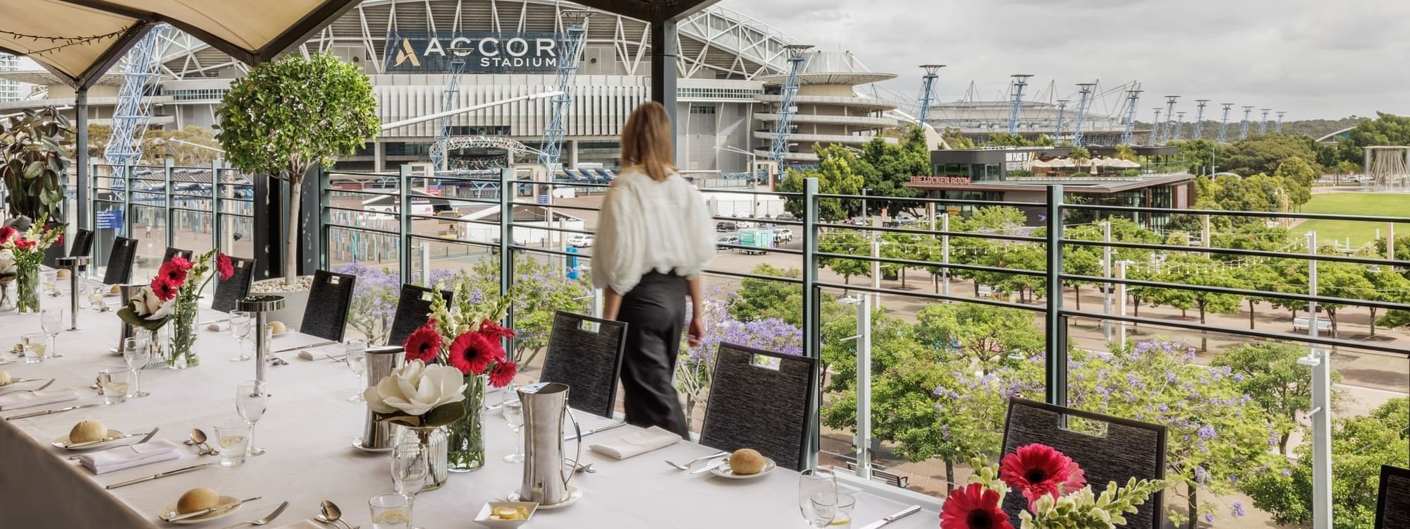 Beautifully set dining table with flowers on Freshwater Balcony, overlooking Accor Stadium at Novotel Sydney Olympic Park