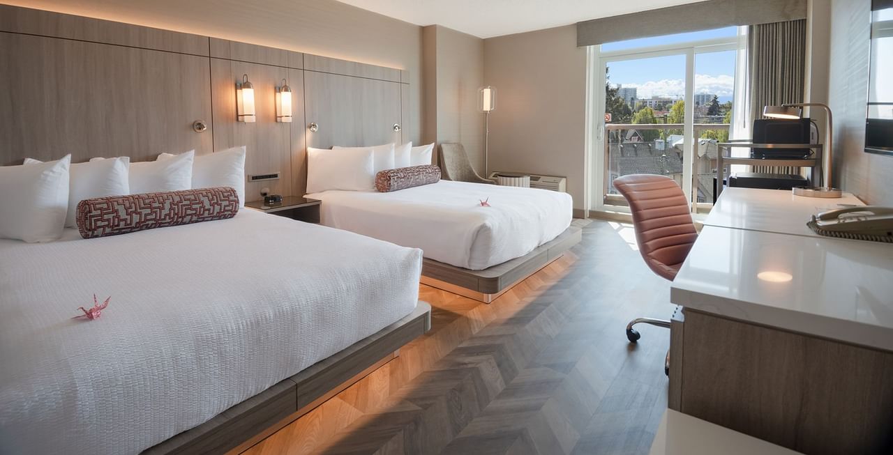 Hotel guestroom with two queen beds and a balcony