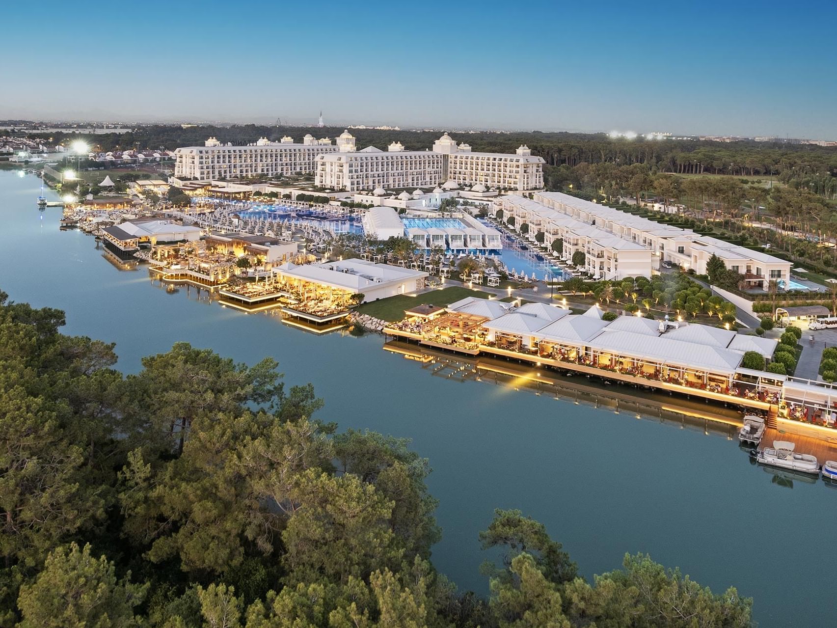 Aerial view of Titanic Deluxe Golf Belek with outdoor pool next to the river and greenery