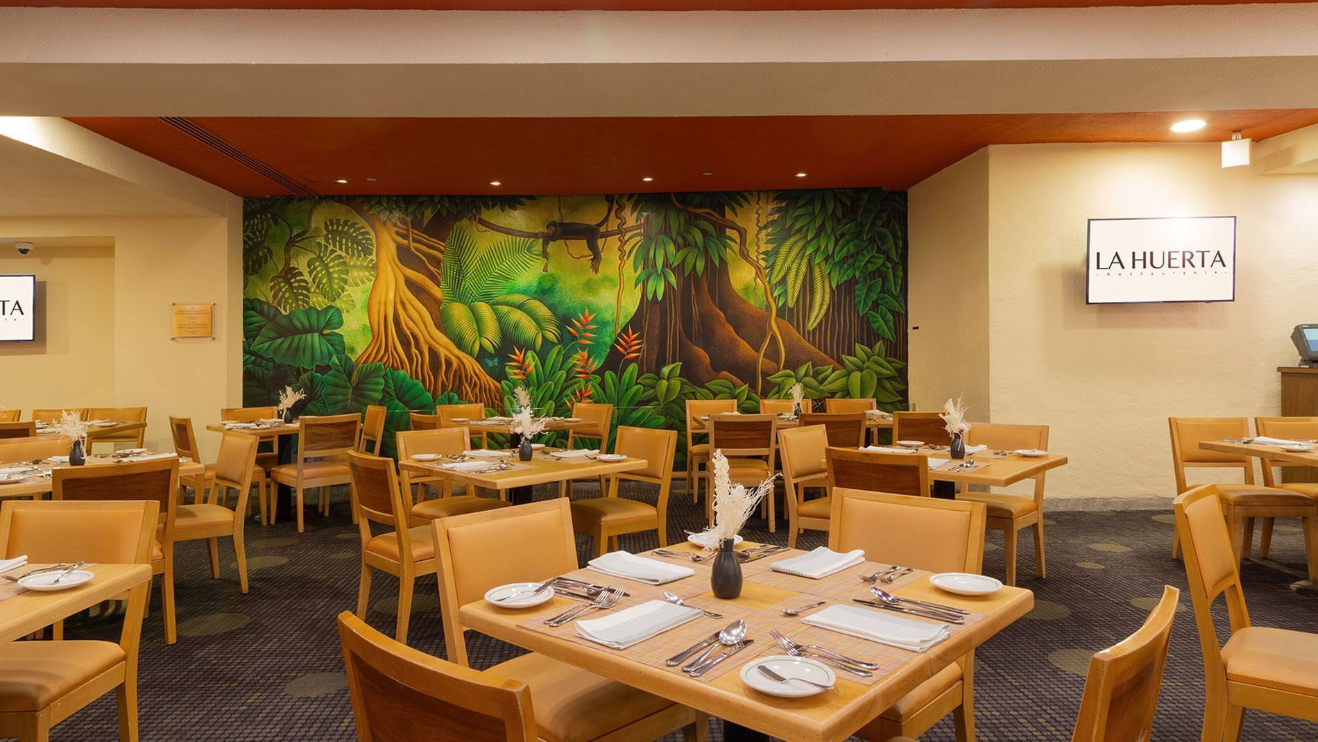 La Huerta Restaurant featuring a lush jungle mural and warm wooden furniture at Camino Real Polanco Mexico