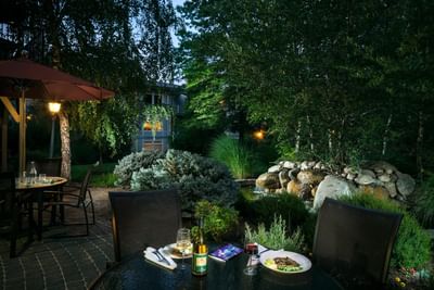 Outdoor dining area and pond of Plaza Inn & Suites at Ashland Creek​