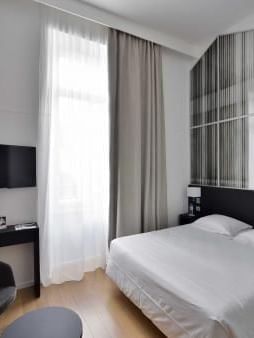King bed, TV & chair in a bedroom at Oceania Hotels Group
