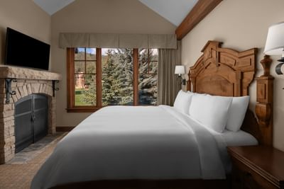 Wall-mounted TV with fireplace facing the bed by the window in Cottage Luxury Suites at Hotel Park City Autograph Collection
