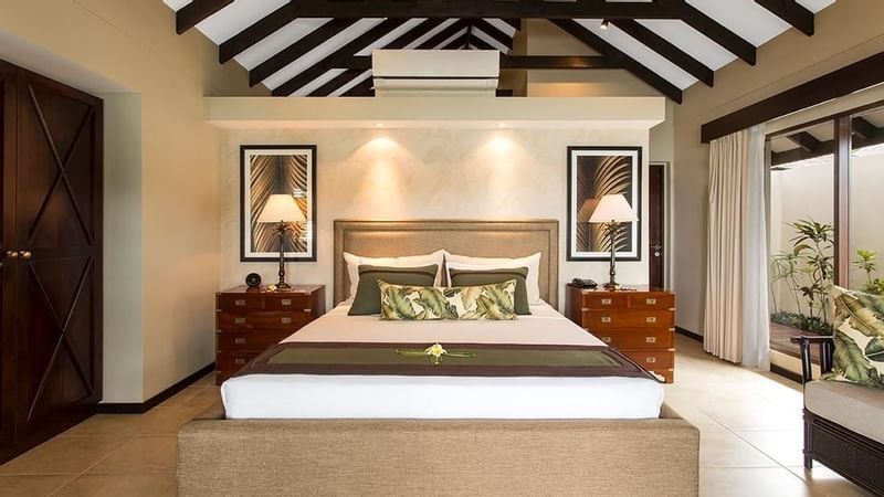 Bed between side lamp tables with wall art in Shefa Pool Villa at warwick le lagon-vanuatu 