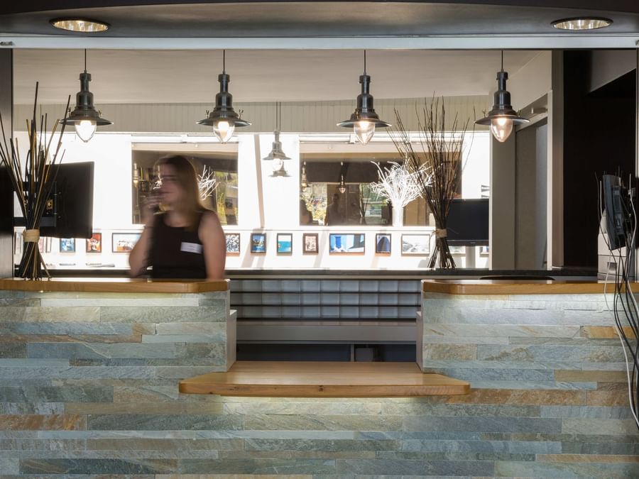 A receptionist at the reception desk in Hotel Au Chene Vert