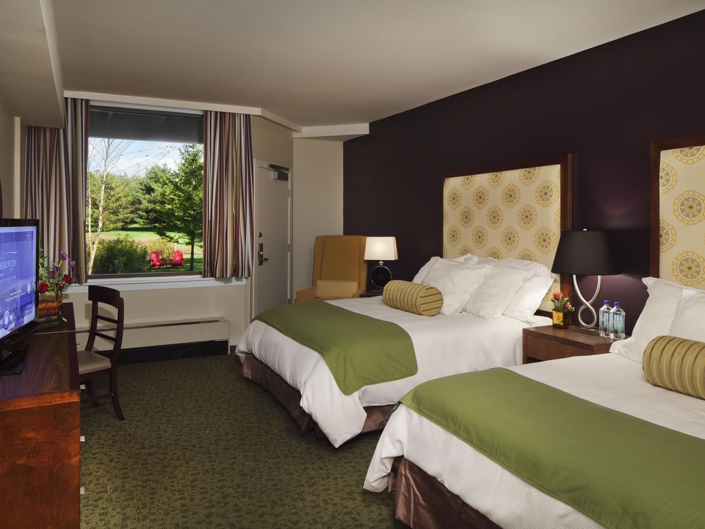 Two double beds with green and white bedding in a room at Aramark Chauncey in Princeton, NJ.