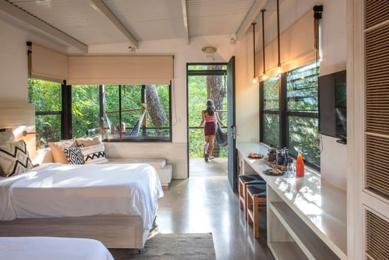Lady in the balcony of East Bugalows with twin beds at Hotel Rio Perdido