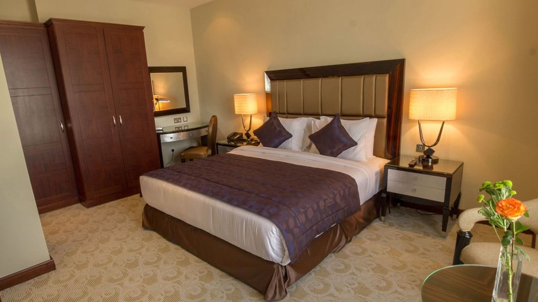 Executive Suite with king bed & side cupboard at Strato Hotel by Warwick Doha