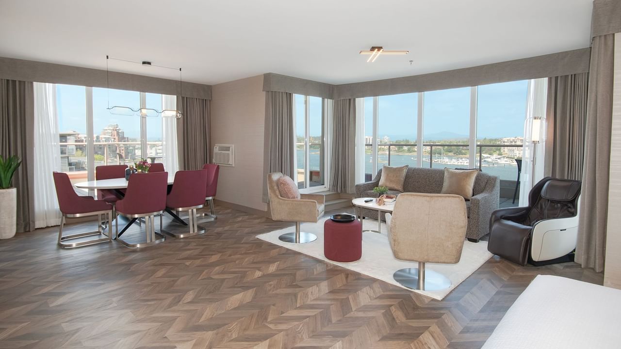 Hotel guestroom with wrap-around balcony, massage chair, and living area