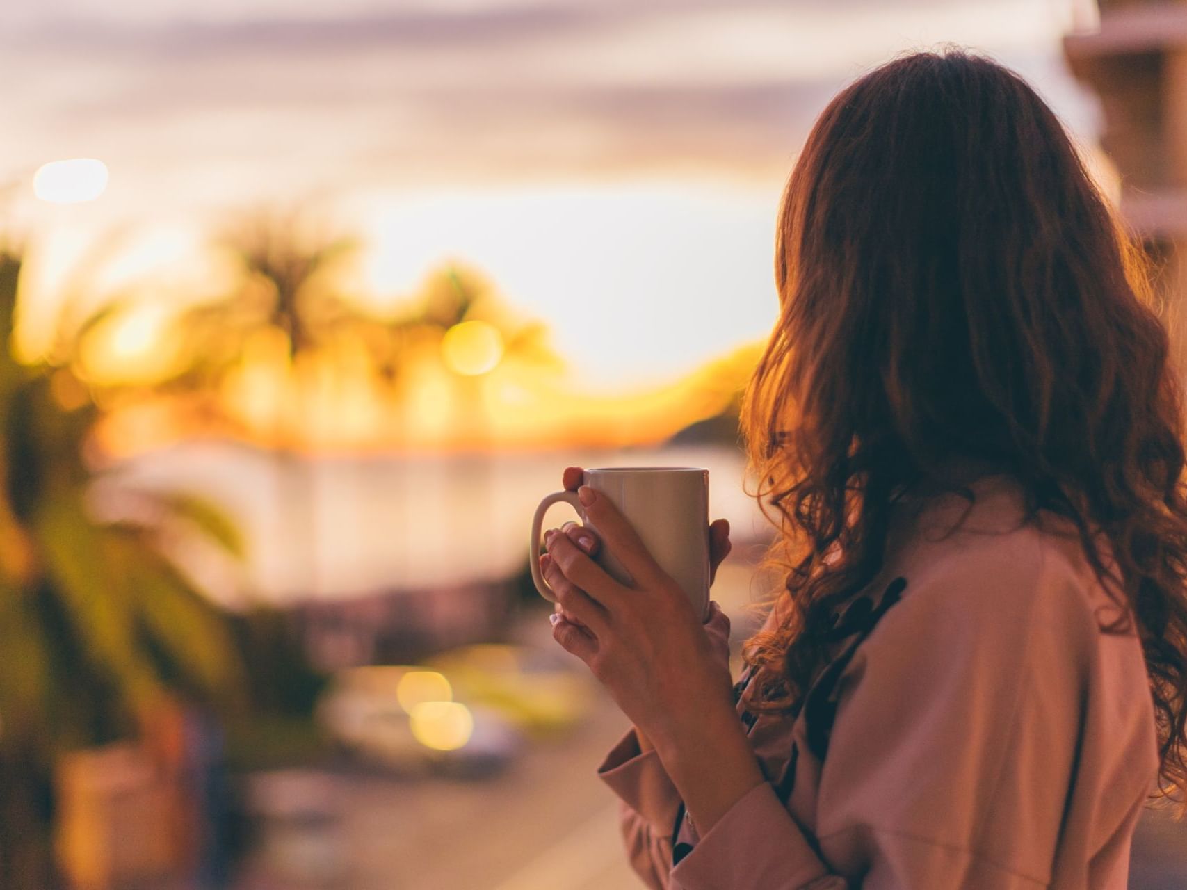 A lady having coffee in a bedroom balcony at Sunseeker Resort