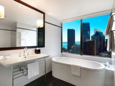Bathtub & vanity area in Deluxe Corner at Amora Hotel Sydney