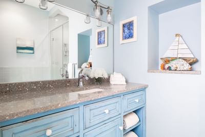 Bathroom vanity with large mirror, fresh flowers & towels in Superior Loft Cottage at Retro Suites Hotel