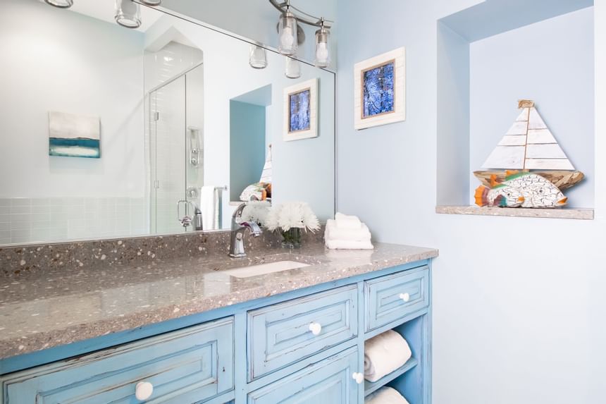 Bathroom vanity with large mirror, fresh flowers & towels in Superior Loft Cottage at Retro Suites Hotel