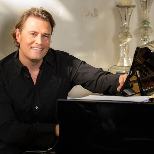 Pasquale Esposito sitting in front of a piano