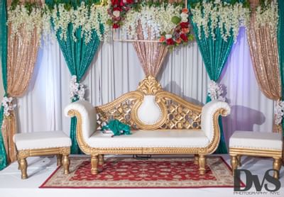 white and gold seating bench with flower wall/curtain décor