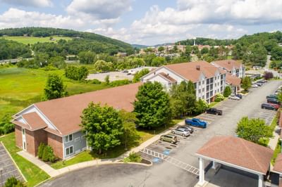 Aerial view of White River Inn and Suites, one of the top White River Junction hotels, surrounded by greenery & a parking lot