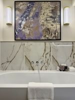 Suite bathroom with marble vanity, modern fixtures, and abstract artwork at The Capital Hotel, Apartments & Townhouse - London