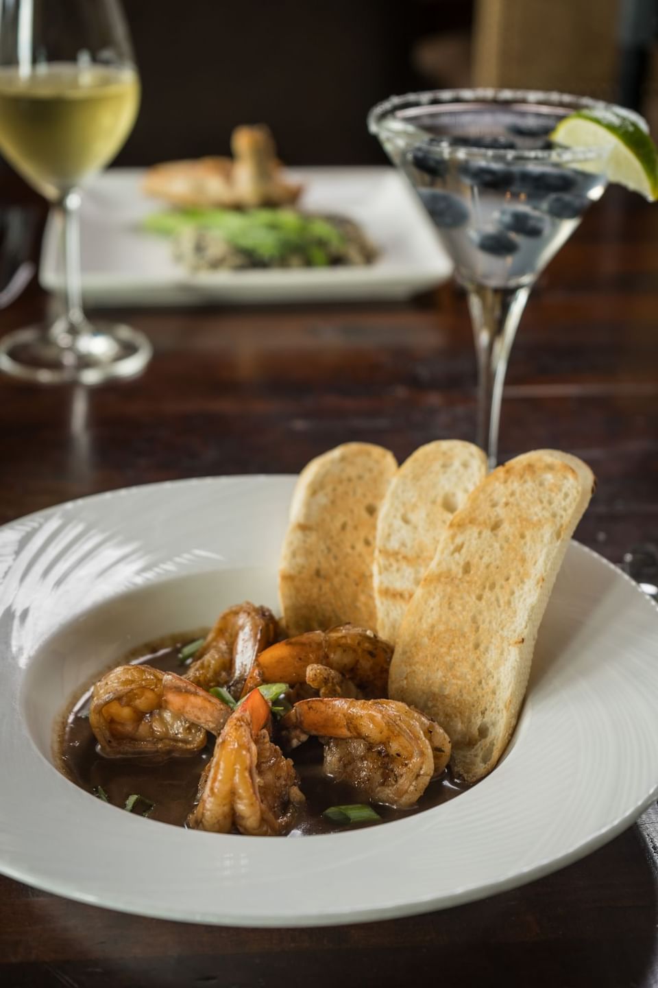 Close-up of Gumbo served with a side of toasts and cocktail at Shangri-La Monkey Island