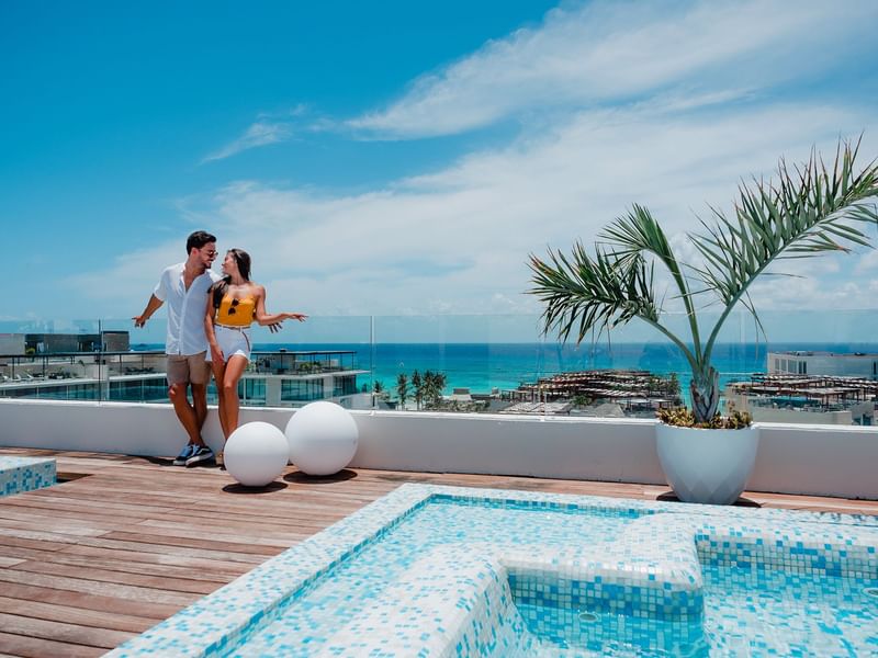 A couple posing by the terrace pool at The Reef 28