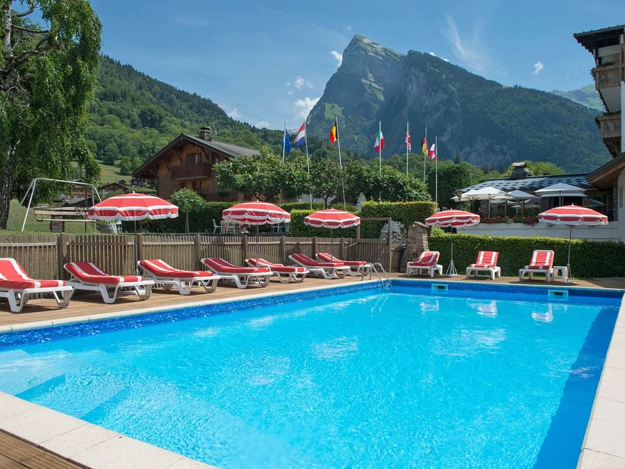 Pool area with sunbeds at Chalet-Hotel Le Labrador