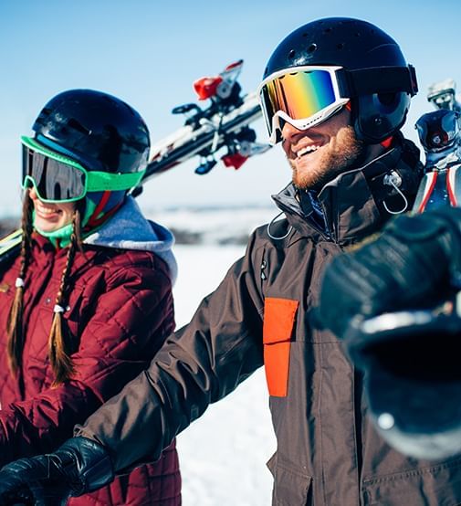 Skiers holding skis on there shoulders