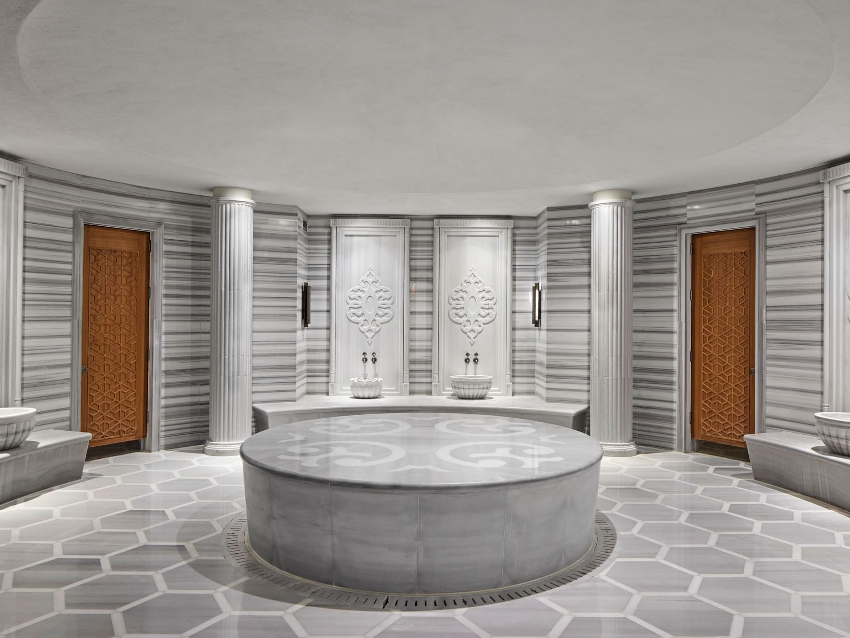 Modernes Hammam mit zentralem Becken, gefliesten Wänden und dekorativen Elementen – Titanic Chaussee Berlin.