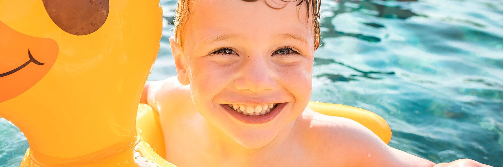 Kid at pool in a duck innertube.