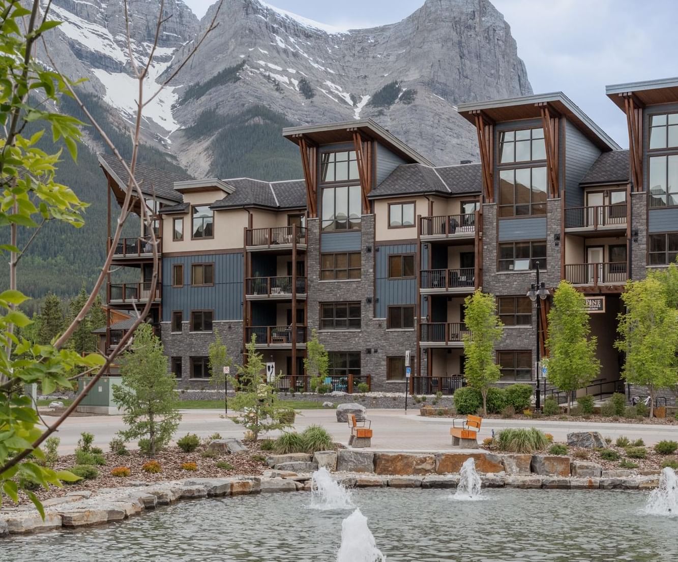Tamarack Lodge with wood accents and fountains in mountain backdrop at Spring Creek Vacations