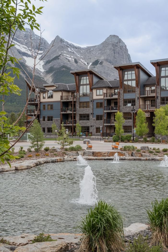 Tamarack Lodge with wood accents and fountains in mountain backdrop at Spring Creek Vacations