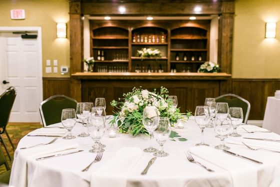 Dining table set with glasses by a wooden bar at Oregon Garden Resort, one of the best places to stay in Silverton