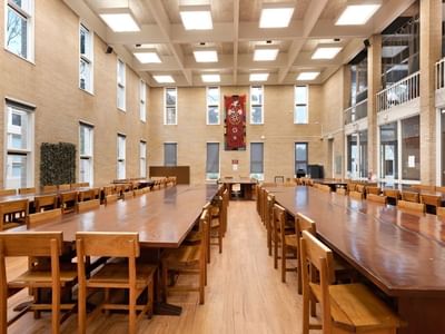 Long wooden tables with chairs in a spacious hall at La Trobe University Glenn College.