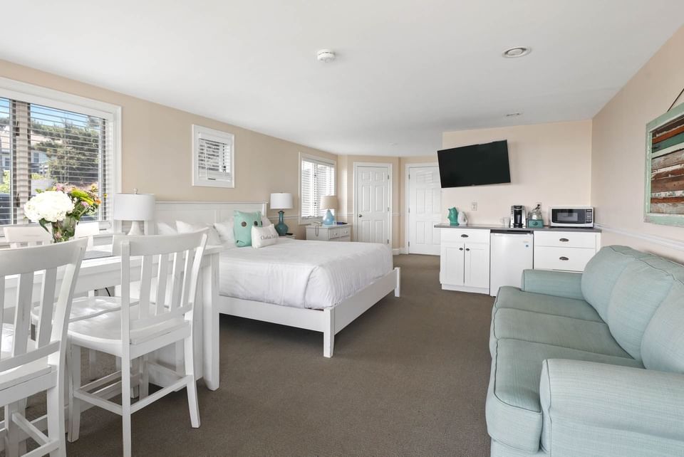 Bed and kitchenette with arranged seating in Suntide Oceanfront King at Chatham Tides Resort