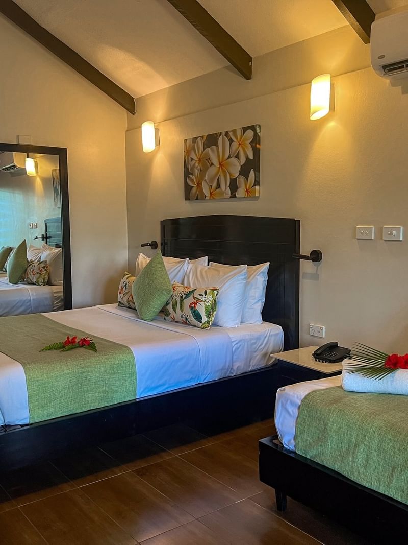 Two beds with floral decor in a Deluxe Villa at Tokatoka Resort - Fiji International Airport in Nadi.