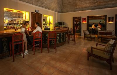 Man and woman sipping cocktails within pavilion bar